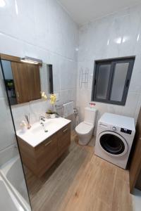 a bathroom with a sink and a washing machine at Seaside Escape Birzebbuga in Birżebbuġa