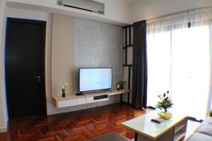 ein Wohnzimmer mit einem Flachbildfernseher an der Wand in der Unterkunft The Mews KLCC Service Suites in Kuala Lumpur