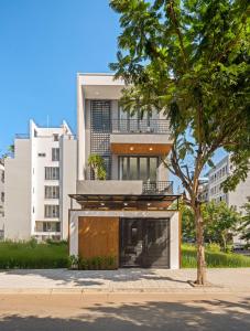 un edificio con una puerta delante de un árbol en N to M Villa-pool 5 mins walk to MyKhe beachFullAC, en Da Nang