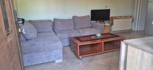 a living room with a couch and a coffee table at FarmHouse near Airport in Paianía