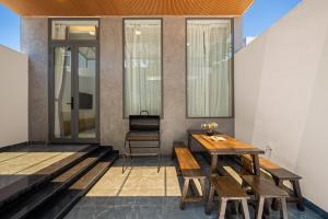 un patio con bancos, una mesa y una silla en N to M Villa-pool 5 mins walk to MyKhe beachFullAC, en Da Nang