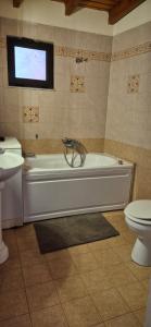a bathroom with a tub and a toilet and a sink at FarmHouse near Airport in Paianía +14 photos