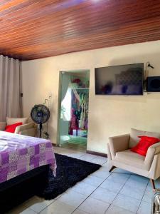 a bedroom with a bed and a couch and a tv at Casa 4Q e Escritorio, ArCond Total, Piscina, WiFi, COP30 in Belém +18 photos