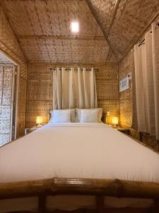 a large white bed in a room with a window at The Bamboo villas 2 in Pooc