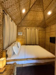Cama grande en habitación con techo en The Bamboo villas 2, en Pooc