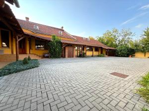 ジュラにあるToscana Apartmanのレンガ造りの私道が目の前にある建物