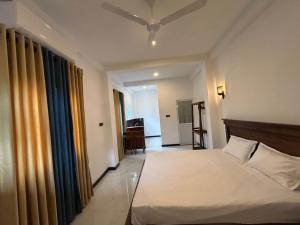 a bedroom with a bed and a room with a desk at Aqua Shade Family Apartment -Weligama in Weligama