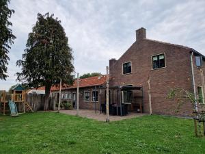 a brick house with a yard in front of it at The Holidayhouse in Loon op Zand