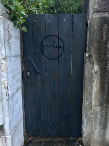 a black gate with the word garden written on it at Un petit cocon in Commercy