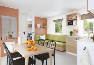 eine Küche und ein Esszimmer mit einem Tisch mit Orangen darauf in der Unterkunft Camping La Montagne in Sorgues