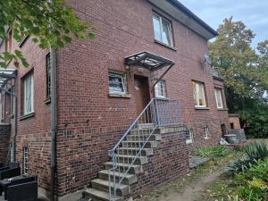 a brick house with stairs leading to the door at Villa im Grünen in Weißenfels