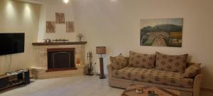 a living room with a couch and a fireplace at STRAVOS-PLATANOS apartement in Naousa