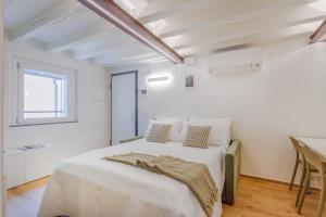 una camera da letto bianca con un letto e un tavolo di Corso Adriano 13 - I Giardini a Modena