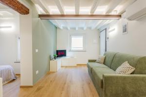 un soggiorno con un divano e una TV di Corso Adriano 13 - I Giardini a Modena