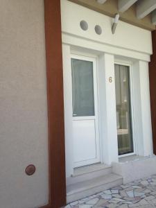 a white front door of a house with stairs at appartamento giorgia in Schio