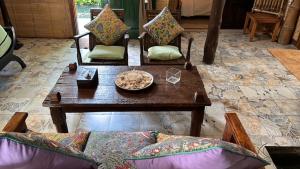 a living room with couches and a table and a couch at Frangipani garden villa in Senggigi