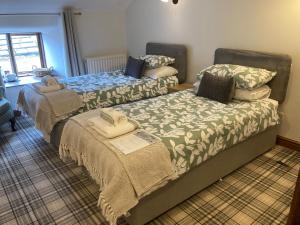 a bedroom with two beds and a laptop on the bed at Jug and glass in Highpeak Junction