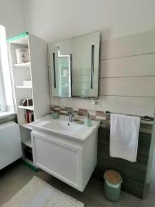 Un baño con un lavabo blanco y un espejo. en B&B Altamarea, en Crotone