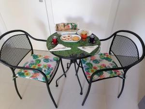 una mesa con un plato de comida y dos sillas en B&B Altamarea, en Crotone