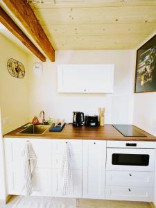 a kitchen with white cabinets and a wooden counter top at Apt in hyper center of Lannion, next to City Hall in Lannion