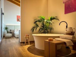 a bathroom with a bath tub and a plant at Tenuta Tommasi - Relais Bacco in Caorle +146 photos