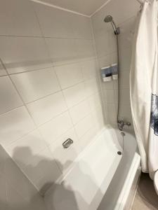 a bathroom with a shower with a white shower curtain at SantiagoCentral in Santiago