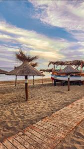 una playa con sombrillas y un barco en la arena en VIVA clara, en Santa Clara del Mar