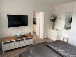 a living room with a bed and a flat screen tv at Ferienwohnung im Harz 3 in Goslar +2 photos