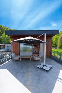un patio con sombrilla y sillas en el techo en Melekona House, en Kartepe