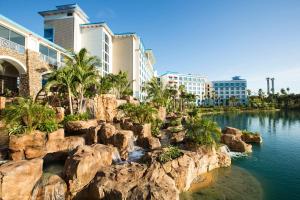 a resort with a river and rocks and palm trees at Universal's Loews Sapphire Falls Resort in Orlando