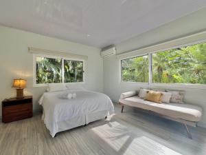 a bedroom with a bed and a couch and windows at Selvatica - Superior Double Room in Punta Uva