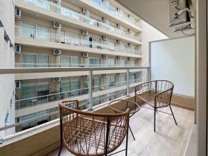 einen Balkon eines Gebäudes mit 2 Stühlen und einem Tisch in der Unterkunft Ayres Suites Moreno in Buenos Aires