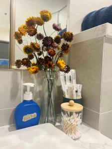 Long BìnhGrace Home Airb&b Apartment的一个插着花的花瓶和一瓶肥皂 更多17张照片