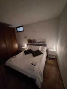 a bedroom with a bed with white sheets and two lamps at La Casa di Mia in Monterotondo
