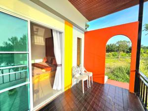 a balcony of a house with a bed and a bedroom at Waew Arun Garden Resort in Ban Na Chik +44 photos