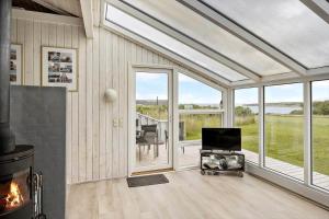 a living room with a fireplace and a screened in porch at G608-Lemvig-Gyvelvej-8 in Lemvig