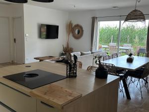 Mauzac-et-Grand-CastangにあるLa Pierre dorée - Love Room - Jacuzzi privatifのテーブルと椅子のあるキッチンとリビングルーム +1枚の写真