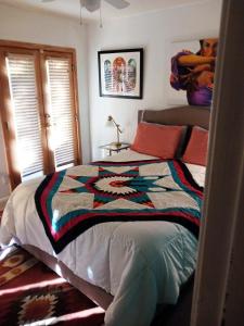 a bedroom with a bed with a colorful quilt on it at Randy's Roost in Santa Fe