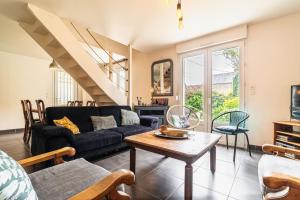 a living room with a couch and a table at Maison lumineuse à 50m de la mer idéale en famille in Riantec