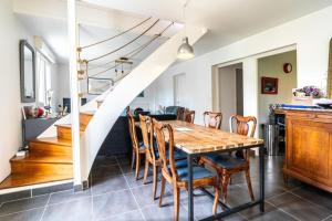 a kitchen and dining room with a wooden table and chairs at Maison lumineuse à 50m de la mer idéale en famille in Riantec