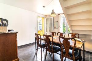 a dining room with a wooden table and chairs at Maison lumineuse à 50m de la mer idéale en famille in Riantec