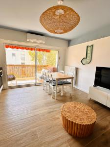 ein Wohnzimmer mit Tisch und Fernseher in der Unterkunft Hacienda - 6 couchages - Terrasse & Garage in Antibes