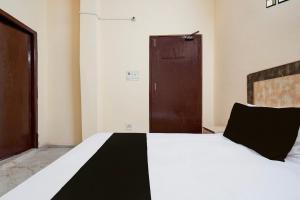 Un dormitorio con una cama con una manta blanca y negra. en Hotel O Vip Stay Inn, en Ghaziabad