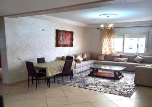 a living room with a couch and a table at Appartement moderne - Résidence privée in Kenitra