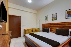 ein Schlafzimmer mit einem großen Bett und einem Fernseher in der Unterkunft Hotel O The Grand Luxury in Noida