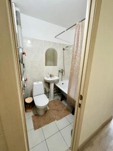a bathroom with a toilet and a sink at Авангард 4-12 in Atyraū