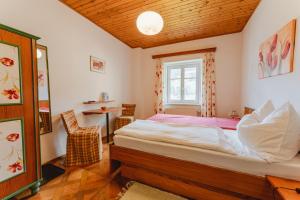 a bedroom with a bed and a table and a window at Frühstückspension Zippo in Greifenburg