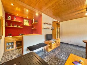 a living room with red walls and a wooden ceiling at Apartamento rural en Los Pirineos in Guardiola de Berguedà