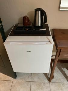 a white stove top oven with a coffee pot on top at HOTEL ΗΩ (ΞΕΝΩΝΑΣ ΤΣΙΑΧΡΗΣ) in Morfovoúnion