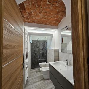 a bathroom with a sink and a toilet and a shower at La Volta di Margherita in Busca +20 photos